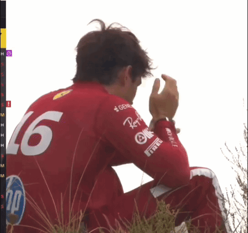 Man in Red Shirt Number 16 Sitting in Grass