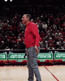 Man in Red Shirt on Basketball Court in Front of PkwyTavern.com Sign