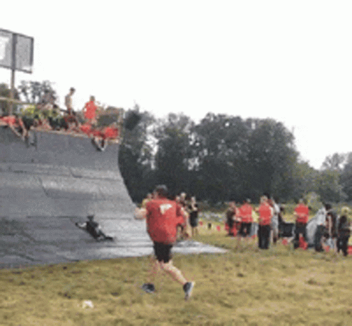 Man in Red Shirt Running Across Field