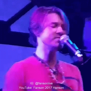 Man in Red Shirt Singing Into Microphone
