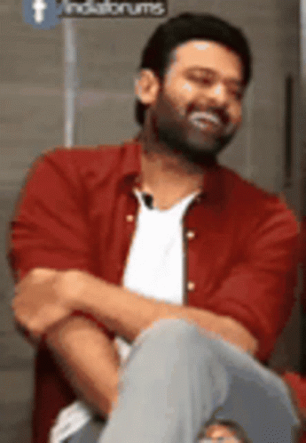 Man In Red Shirt Sitting With Arms Crossed Smiling GIF