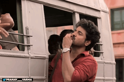 Man in Red Shirt Standing Before Bus Pranay Varma