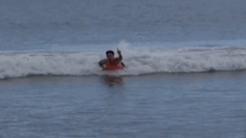 Man in Red Shirt Surfing Ocean