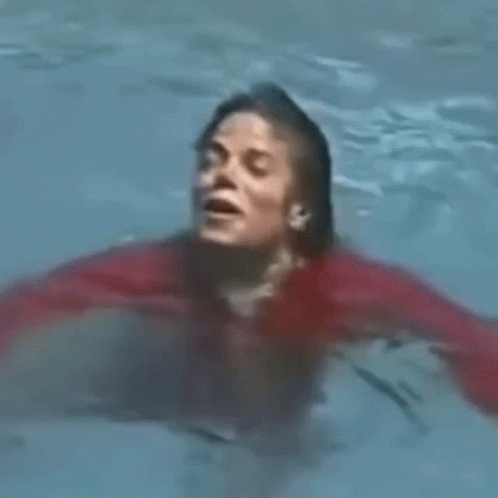 Man in Red Shirt Swimming With Mouth Open