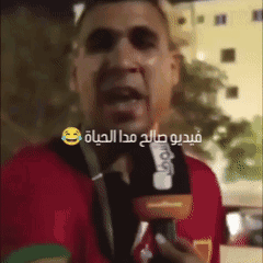 Man in Red Shirt Talking Into Microphone