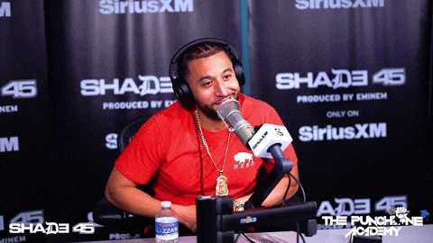Man in Red Shirt Talking Into Microphone
