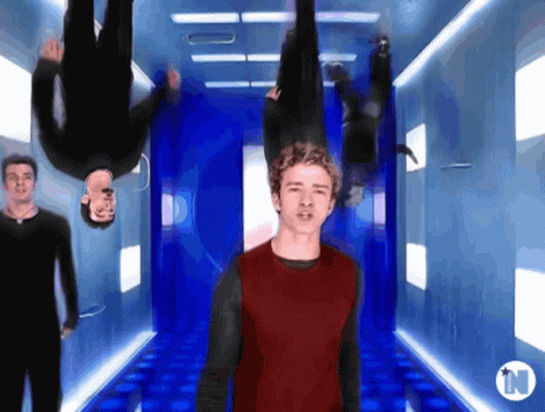 Man in Red Shirt Upside Down in Hallway With N