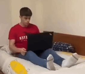 Man in Red Shirt Using Laptop