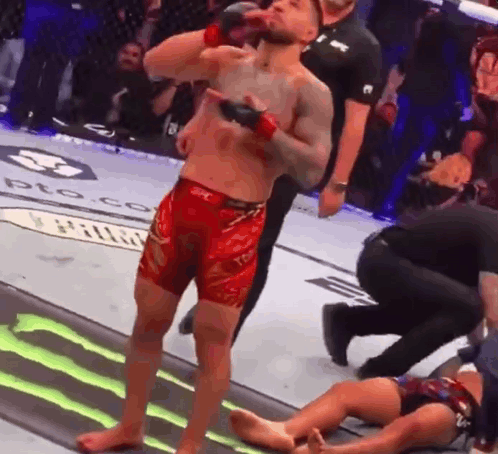 Man In Red Shorts Beside Man In Cage GIF