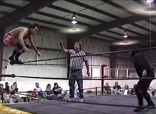 Man In Red Shorts Jumping As Referee Looks On GIF