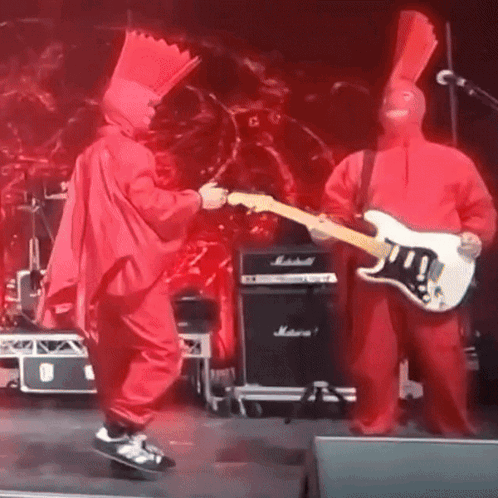 Man in Red Singing into Microphone on Stage