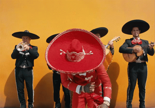 Man in Red Sombrero Surrounded by Musicians