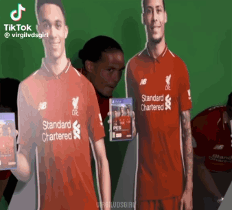 Man in Red Standard Chartered Shirt Holding Video Game