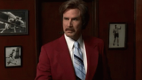 Man in Red Suit and Blue Tie Holding Toothbrush