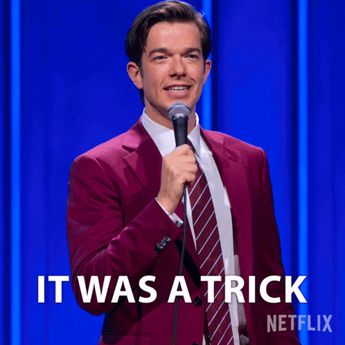 Man In Red Suit And Tie Holding Microphone Saying It Was A Trick GIF