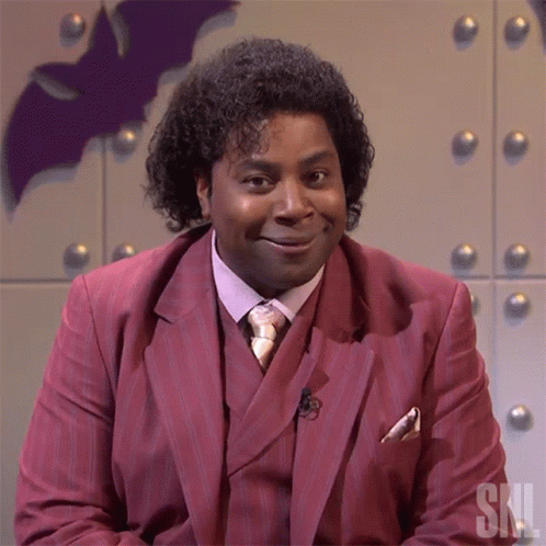 Man in Red Suit and Tie with SNL Letters