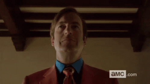 Man in Red Suit Holding Black Briefcase with AMC.com Sign