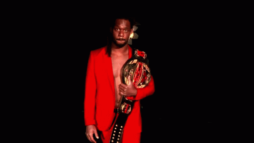 Man in Red Suit Holding Championship Belt