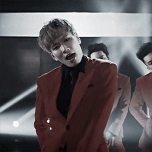 Man in Red Suit Singing Into Microphone