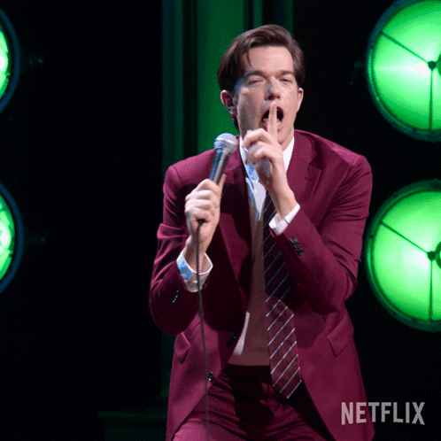 Man in Red Suit Singing Into Microphone Netflix