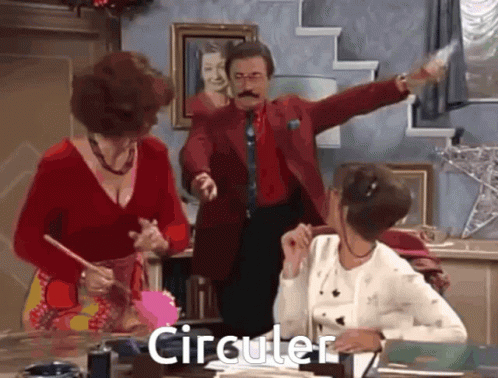 Man in Red Suit Standing Before Two Women Saying Circular