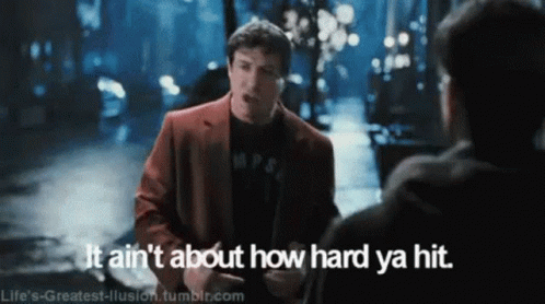 Man In Red Suit Talking To Another Man Says It Ain't About How Hard Ya Hit GIF