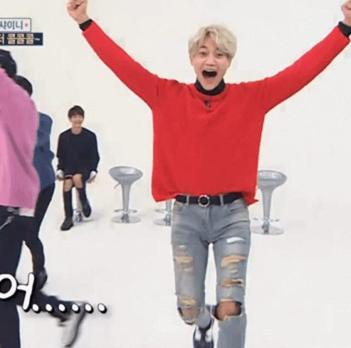Man in Red Sweater and Ripped Jeans Jumping
