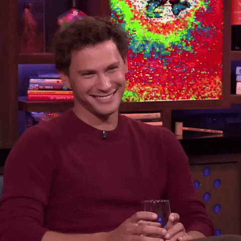 Man in Red Sweater Holding Glass of Wine Smiling