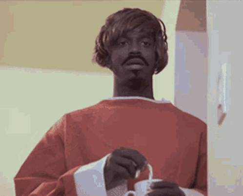 Man in Red Sweater Holding White Cup