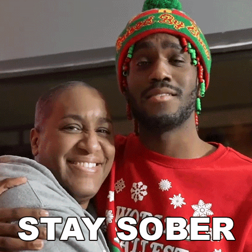 Man in Red Sweater Hugging Woman in Green and Red Hat