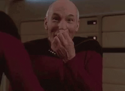 Man in Red Sweater Laughing Hands Over Mouth