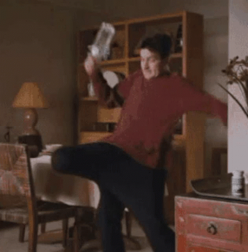 Man In Red Sweater Standing In Living Room GIF