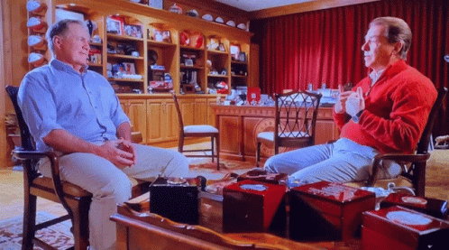 Man in Red Sweater Talking to Another Man
