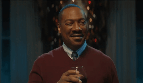 Man in Red Sweater Tie Smiling Holding Wine