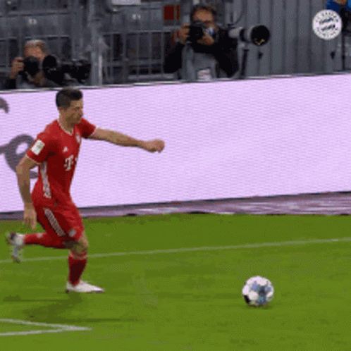 Man in Red T-Mobile Jersey Kicks Soccer Ball