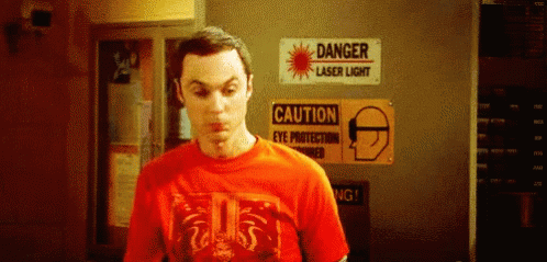 Man In Red T-Shirt In Front Of Danger Laser Sign GIF