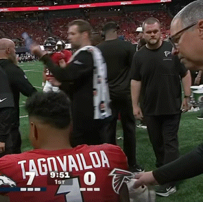 Man In Red Tagovailoa Jersey Sitting On Football Field GIF
