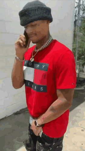 Man in Red Tommy Jeans Shirt Talking on Cell Phone