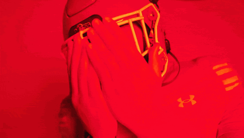 Man in Red Under Armour Shirt Covering Face