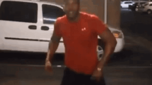 Man In Red Under Armour Shirt Standing In Front Of White Van GIF