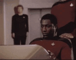 Man in Red Uniform Sitting at Computer