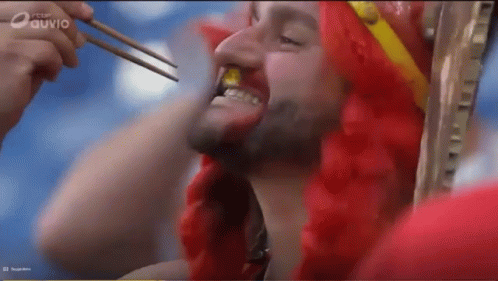Man in Red Wig Eating With Chopsticks on Ouvio Screen
