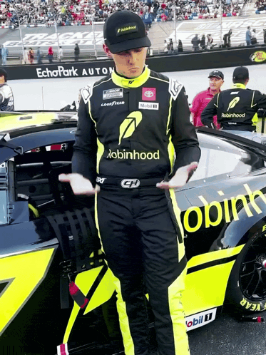 Man in Robin Hood Shirt Beside Race Car