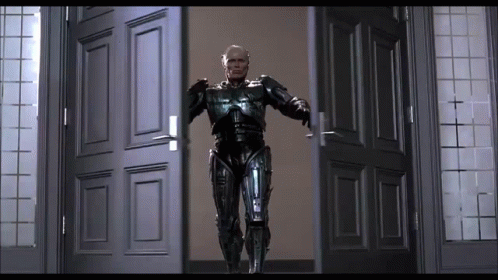 Man in Robot Suit Standing in Doorway With Arms Outstretched