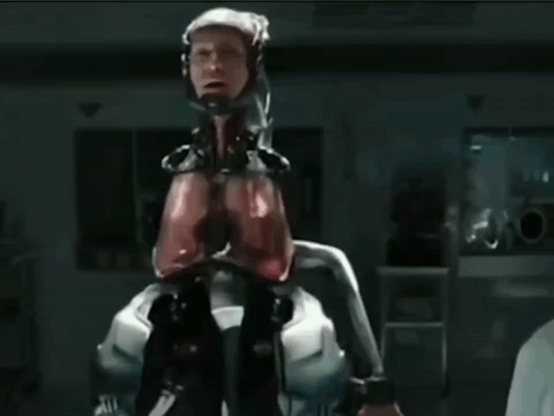 Man In Robotic Suit Near Emergency Exit Sign GIF