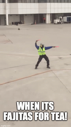 Man in Safety Vest Jumping With Sign Saying When It's Fajitas for Tea