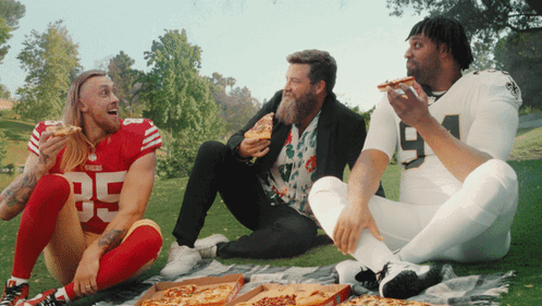 Man in San Francisco 49ers Jersey Eating Pizza on Blanket