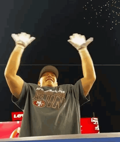 Man in San Francisco 49ers T-Shirt Holding Hands Up