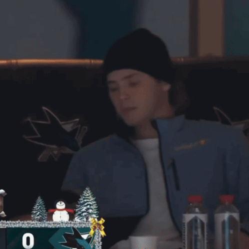 Man in San Jose Sharks Jacket Looking at Phone