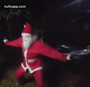Man In Santa Costume Dancing In Front Of Car GIF